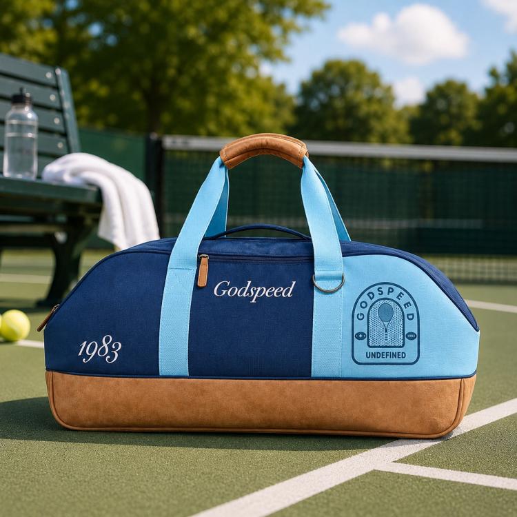 Navy and light blue sports tote bag with tan base, padded handles, Godspeed and Pelta logos.
