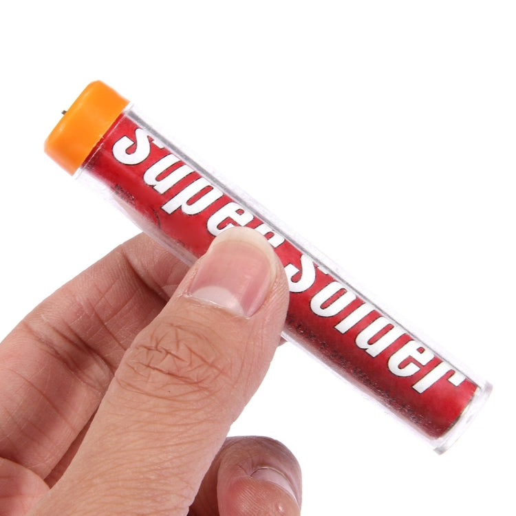 Hand holding a red Super solder flux-cored solder wire stick with orange cap