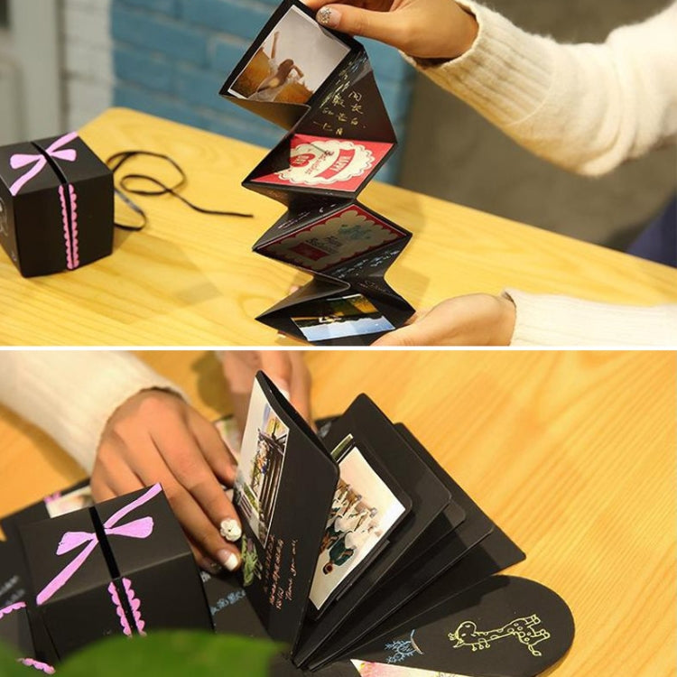 Person opening a black photo explosion album, lifting photo cards from the folded structure