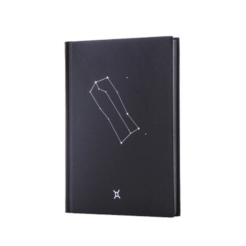 Dark paper notebook with constellation line art and small hourglass icon on cover