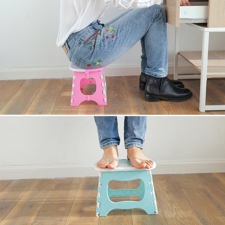 Plastic folding stool with pink and light-blue versions, shown supporting feet indoors