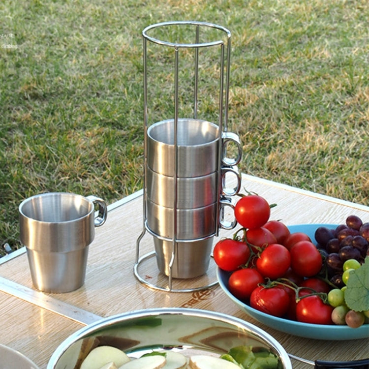 Stainless steel camping coffee cups with handles, two mugs and stand on tabletop