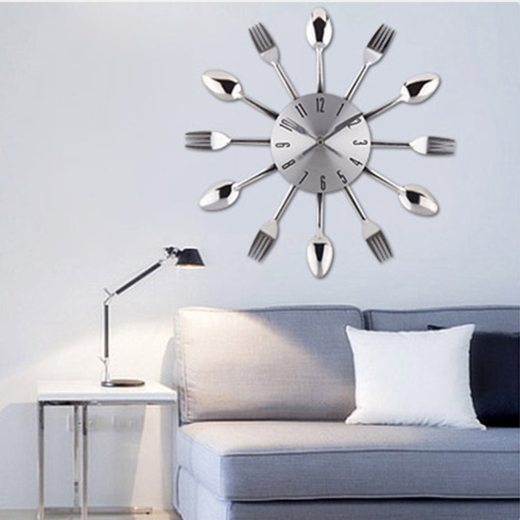 Utensil-themed wall clock with silver fork and spoon arms, round white clock face