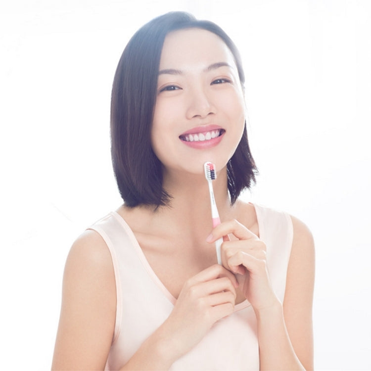 Woman holding a soft manual toothbrush with blue bristles for brushing