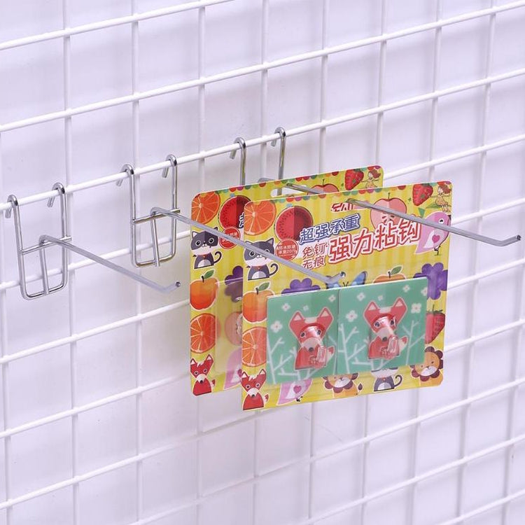 Metal shelf hooks holding colorful postcards on white wire grid