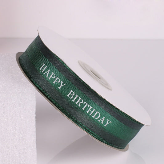 Green satin ribbon roll with “HAPPY BIRTHDAY” printed in a strip ribbon