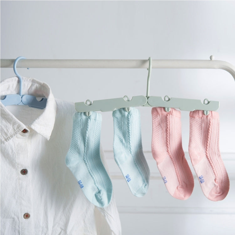 Foldable clothes hanger drying rack with four clips holding pastel socks on a bar