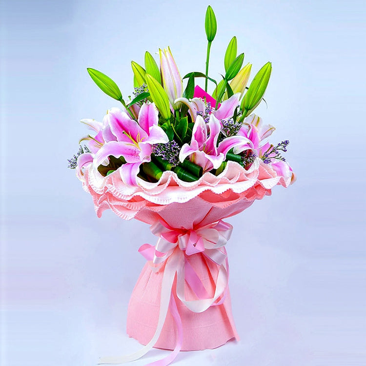 Pink paper flower bouquet centerpiece with ribbon wrap and green stems