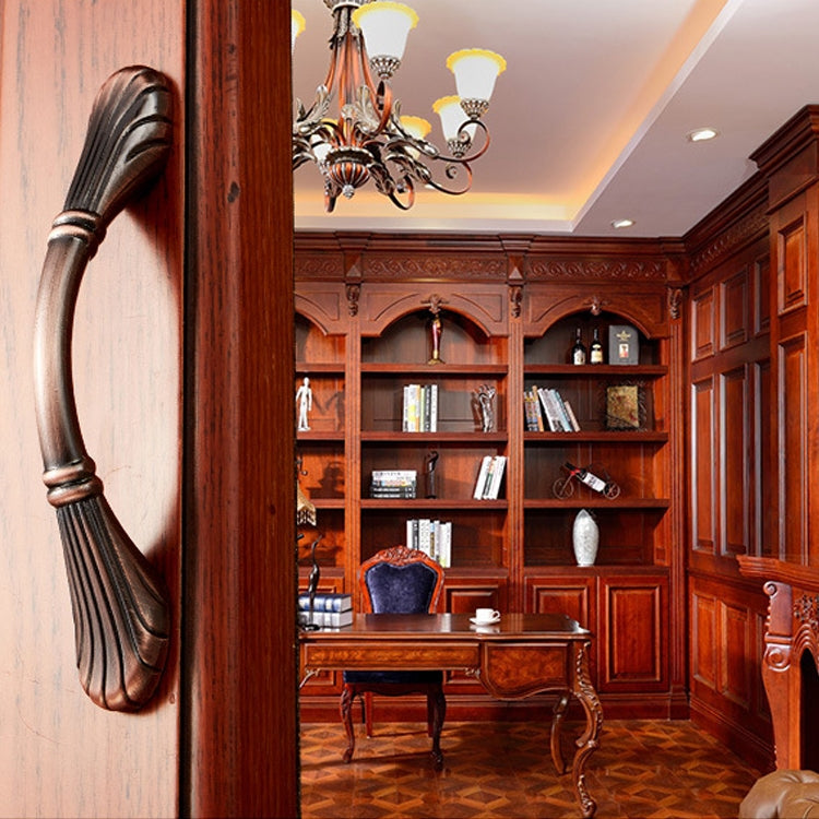 Large bronze arched cabinet handle on wooden cabinet door