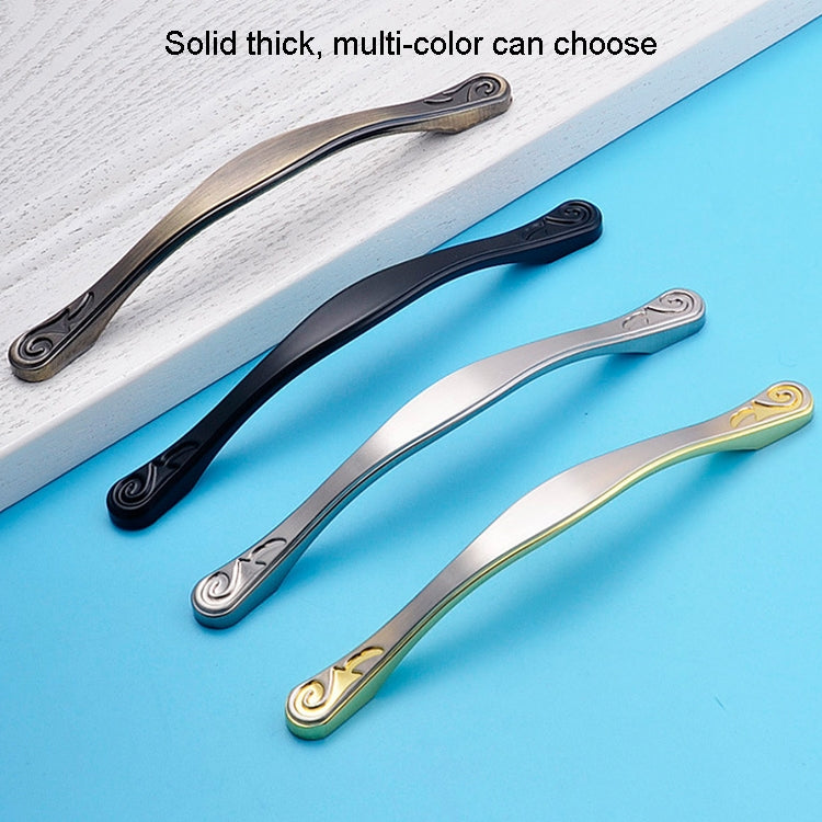 Set of curved cabinet handles in black, silver, and gold with swirl end caps