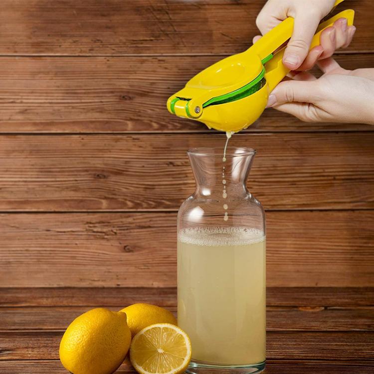 LsCook manual lemon juicer, yellow with green accents, pouring into a glass bottle