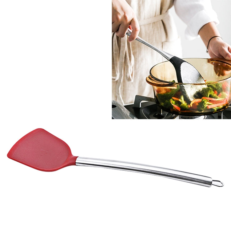 Red silicone spatula slice tool with stainless handle and hanging loop, angled view