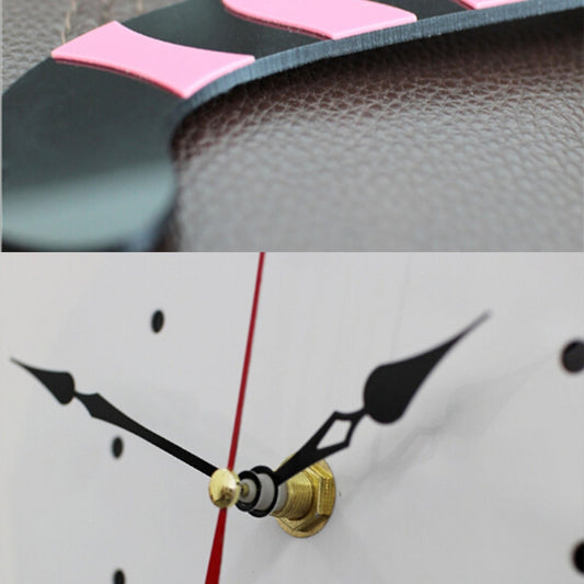 Close-up of cat wall clock hands with red second hand and gold center
