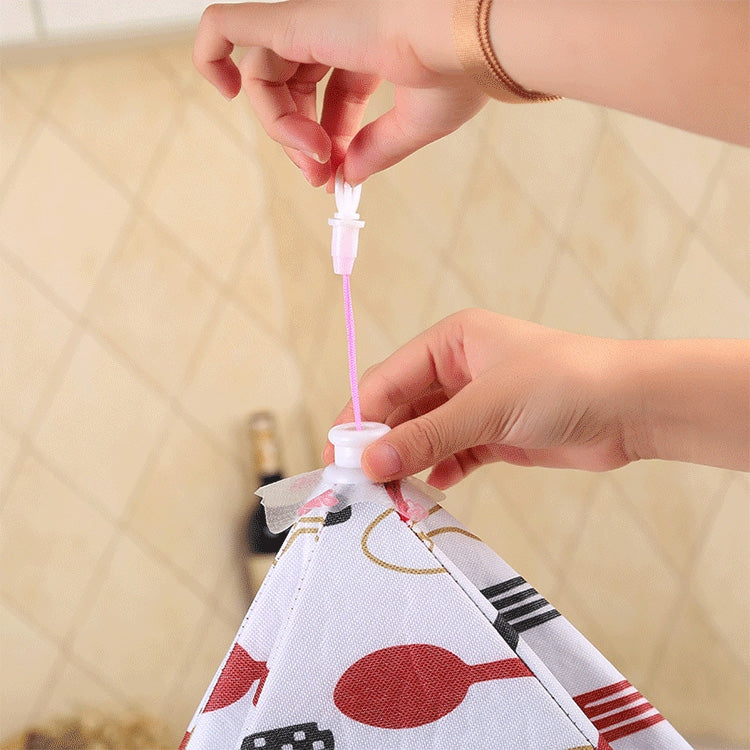 Folding aluminum foil food cover with tie closure on white patterned fabric