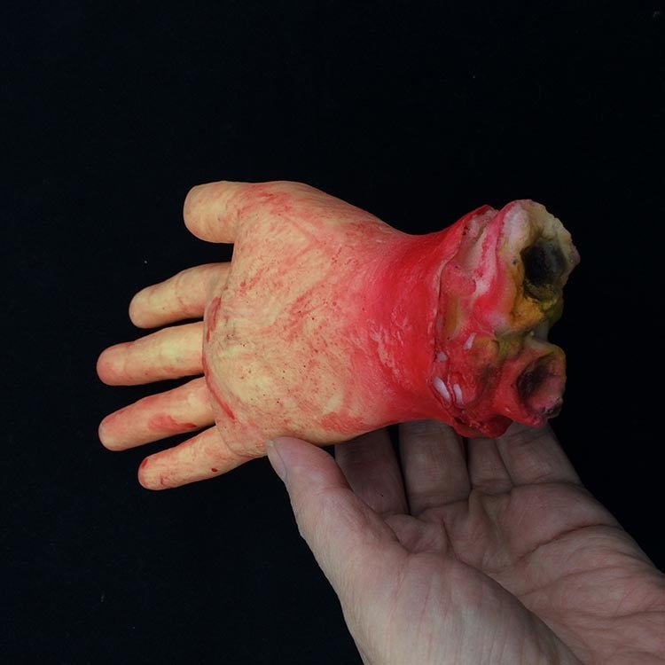 Beige bloody hand prop held in hand, red-stained cut wrist and fingers