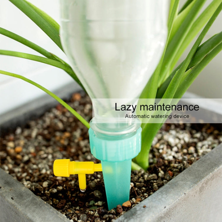Transparent micro-spray irrigation arrow inserted in soil beside green plant stems