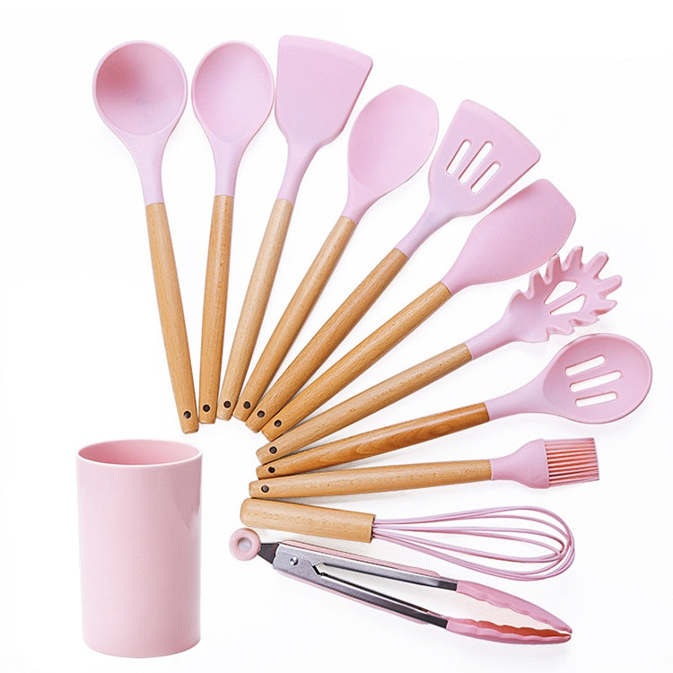 Pink silicone kitchen tool set with wooden handles and matching storage bucket