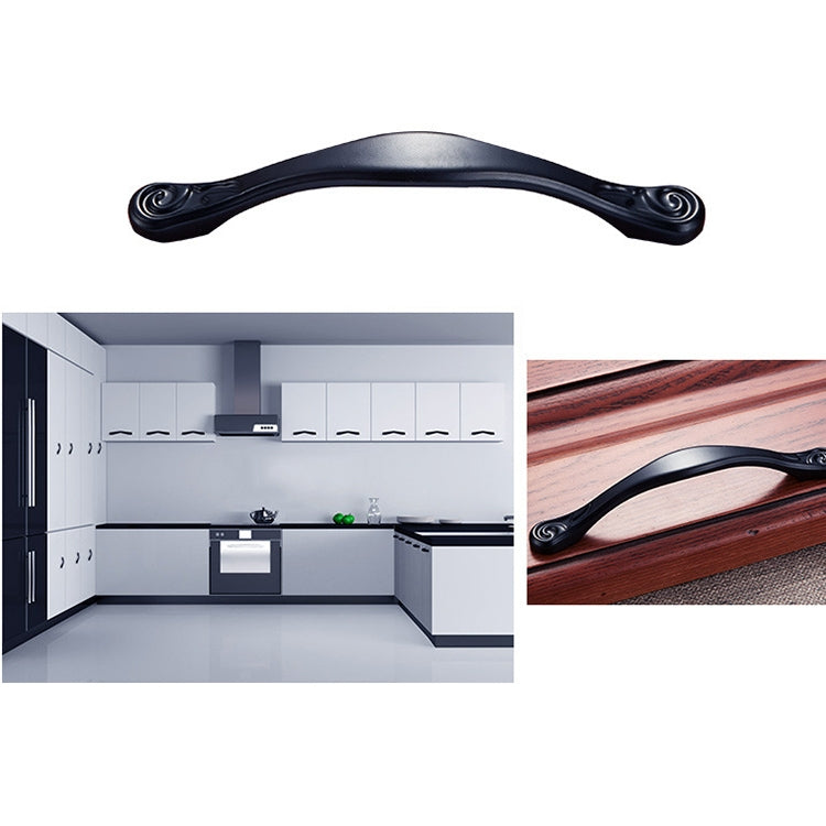 Black arched cabinet handle on wooden cabinet drawer, matching pull shape