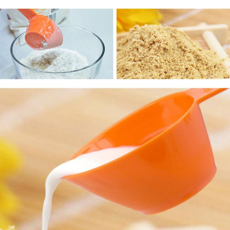 Orange plastic measuring cup pouring dry ingredient, pointed spout and handle