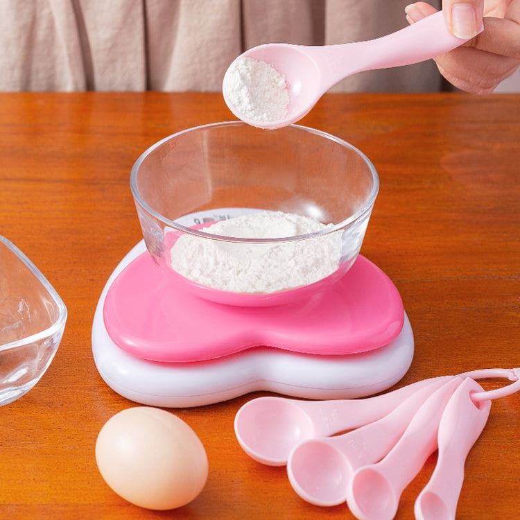 Pink plastic measuring spoon set with multiple scoops and ring handles