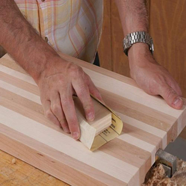 Wet and dry sandpaper sheet sanding a wooden board, held by hand