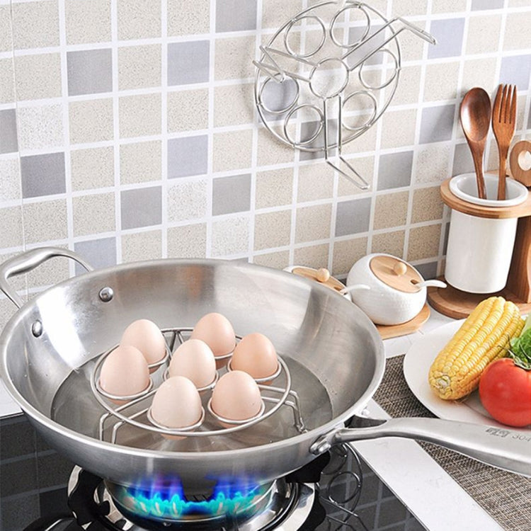 Egg steaming rack trivet over a pot on a stovetop with seven egg slots