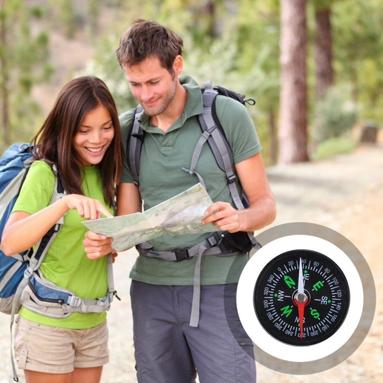Pocket compass graphic with black dial, red pointer, green cardinal letters