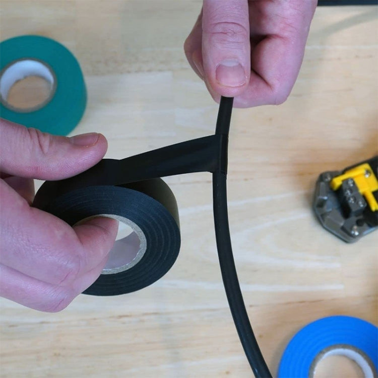 Black electrical insulating tape being wrapped around a cable by hand