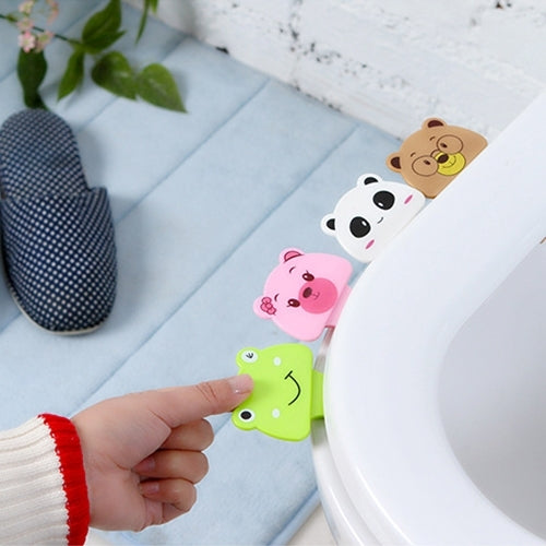 Cartoon toilet lid cover set with panda, bear, and pig faces along the rim; hand holding green