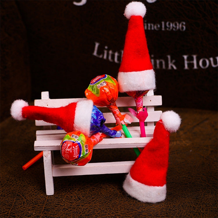 Mini red felt Santa hats with white trim and pom on candy lollipop sticks, with wrapped sweets