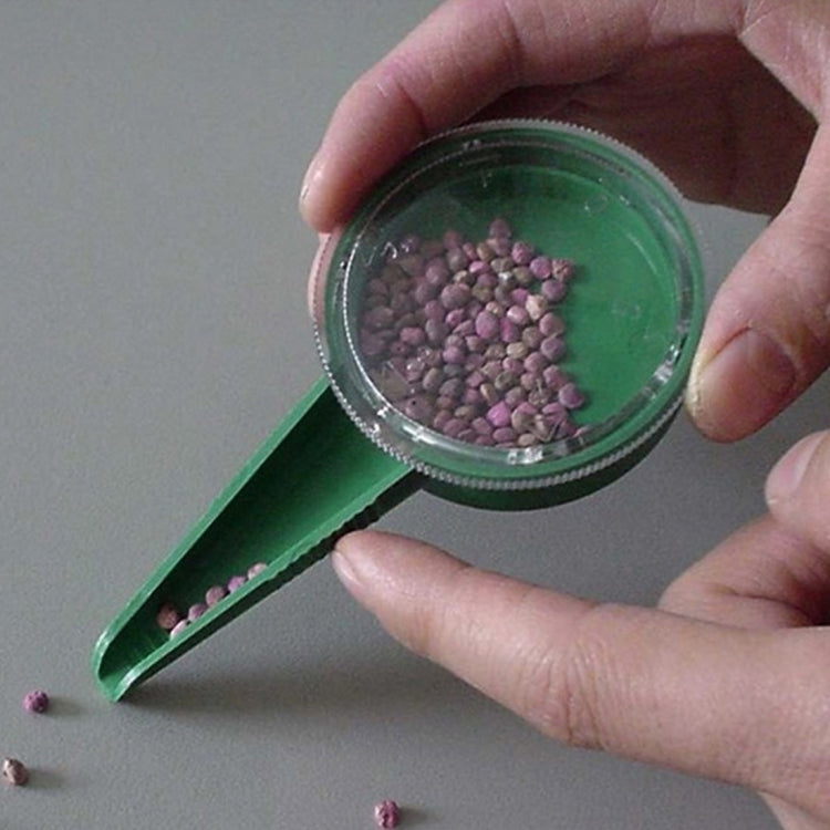 Handheld seed sowing tool filling the clear dial with purple seeds