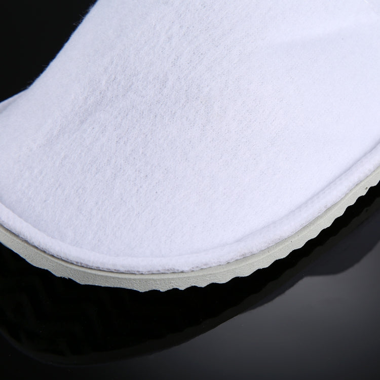 Close-up of white fabric slipper upper with stitched edge and grippy sole