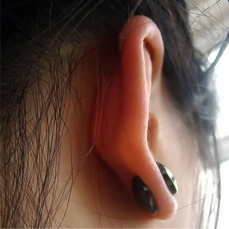 Close-up of a round black magnetic therapy earring in silver-toned housing