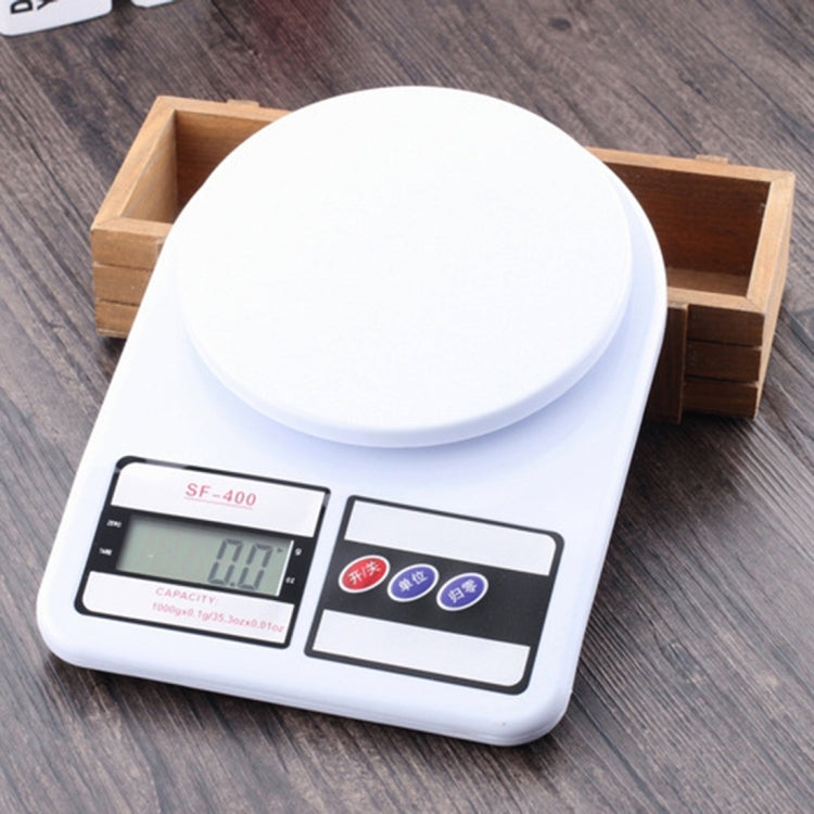 White digital kitchen scale set on a wooden tray with display showing weight