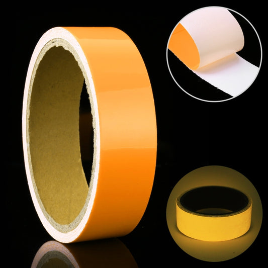 Photoluminescent tape roll, orange-yellow with adhesive backing; close-up of tape edge