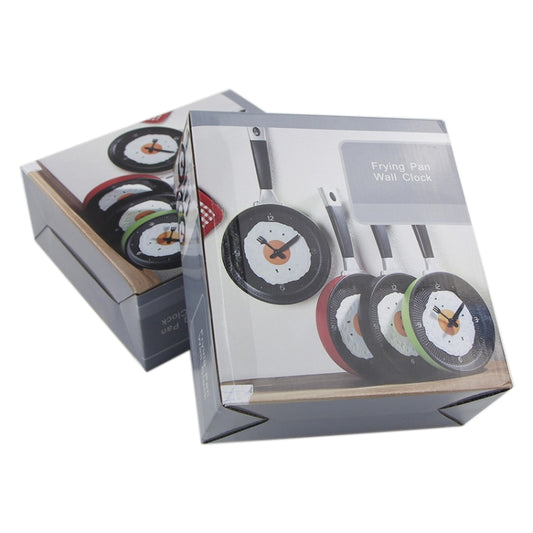 Pan-shaped wall clock in box packaging, showing black dial with orange yolk design