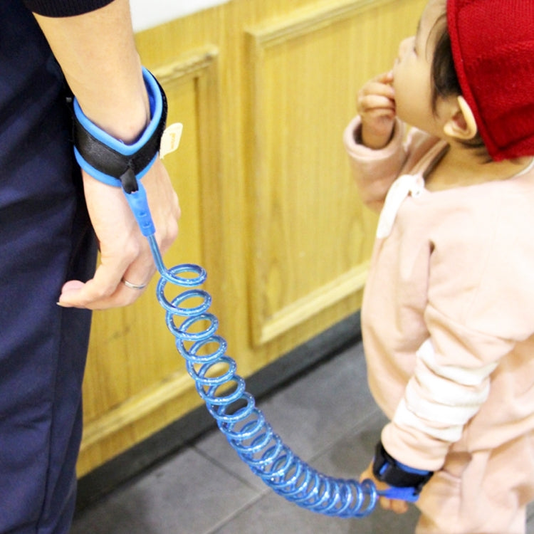 Close-up blue kids safety wrist leash with spring coil rope and padded cuffs