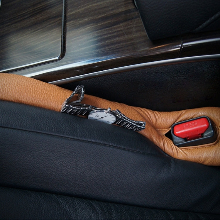 Car seat gap filler pad on car seat, tan faux-leather strip near seatbelt latch