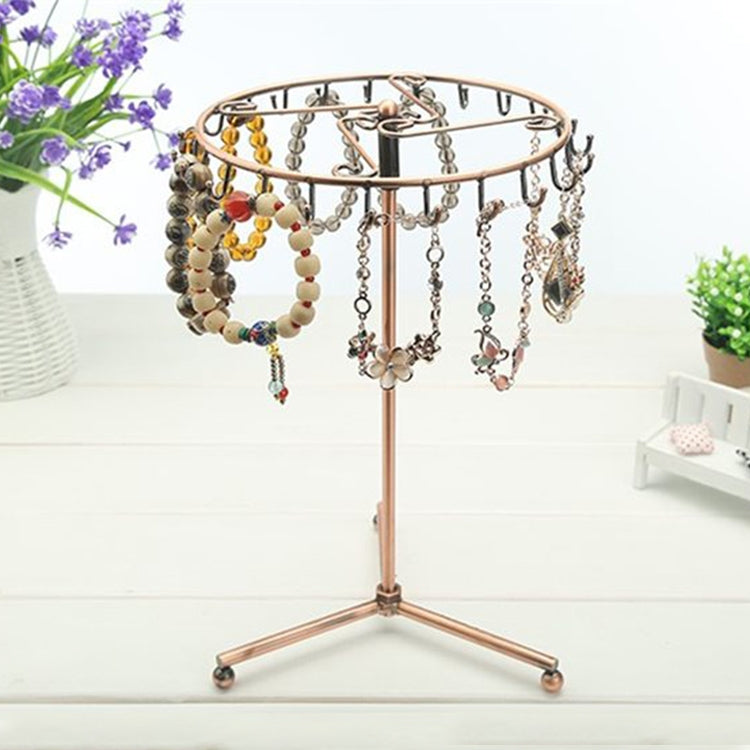 Rose gold rotating jewelry display stand with many hanging necklaces and charms