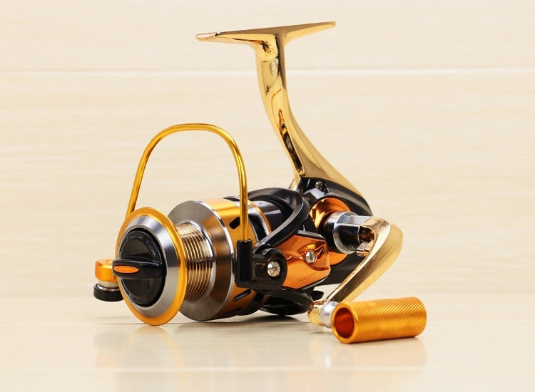 All-metal spinning fishing reel with gold finish, black spool, and orange handle grips