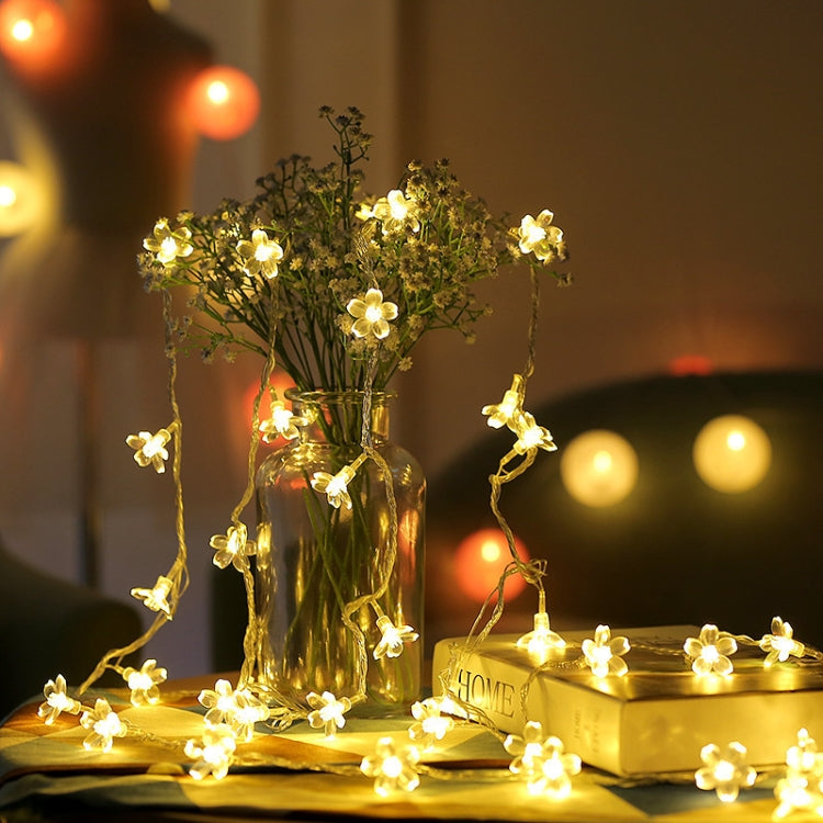 Warm white cherry blossom LED light string, glowing gold flower bulbs in clear vase