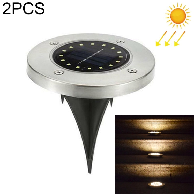 Solar LED buried ground light, round silver top with dark center and spike stake