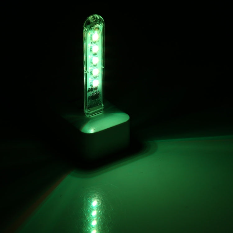 Small green LED night light with 5 glowing bulbs on a white base
