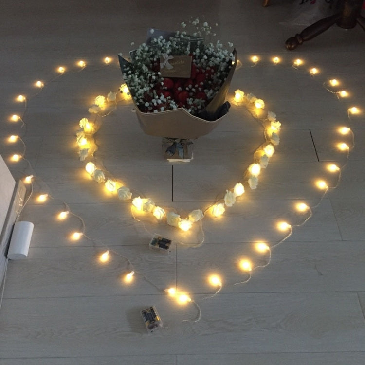 Warm rose-shaped LED fairy lights draped across a ceiling and wall