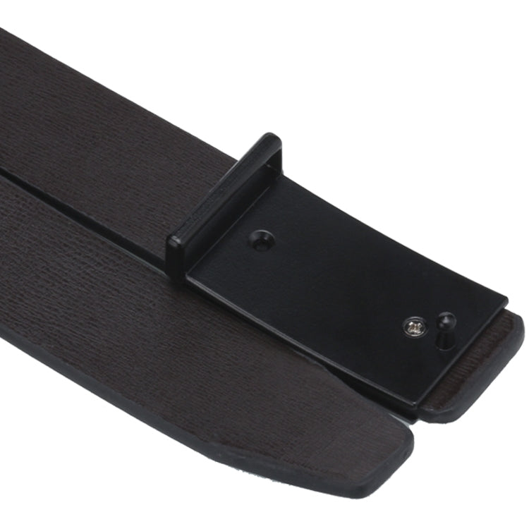 Black belt buckle close-up on dark leather strap with hole openings