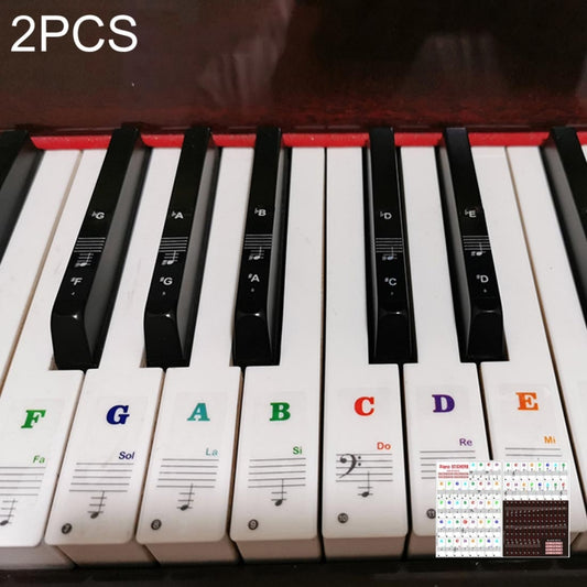Piano scale key stickers on white keys, labeled A–G with note staff and icons