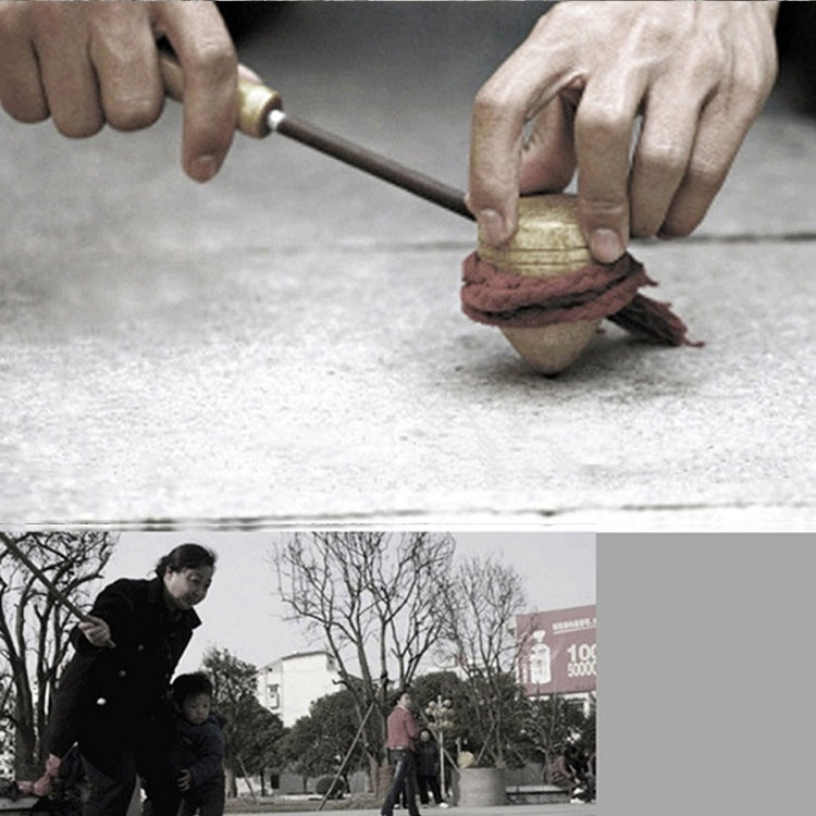 Hands launching a wooden cone spinning top using a metal rod and red-string launcher