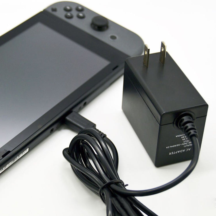 Black AC adapter with Type-C cable connected to handheld console