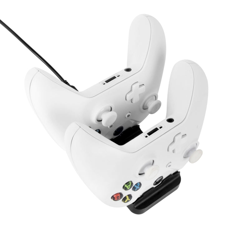 White controller docked for charging, showing bottom contacts aligned to base.