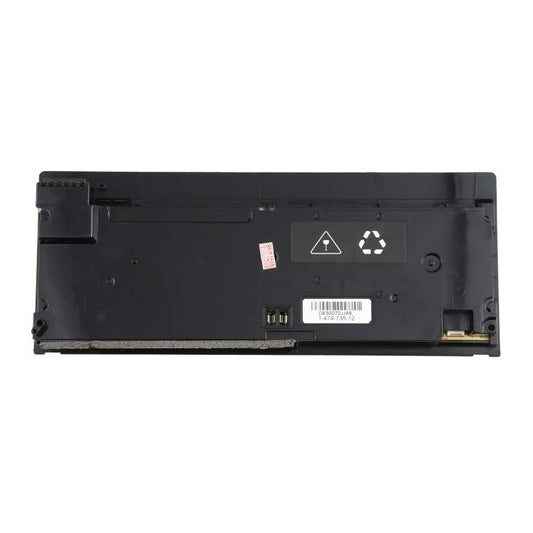 Game console power supply underside with warning icons and connector socket